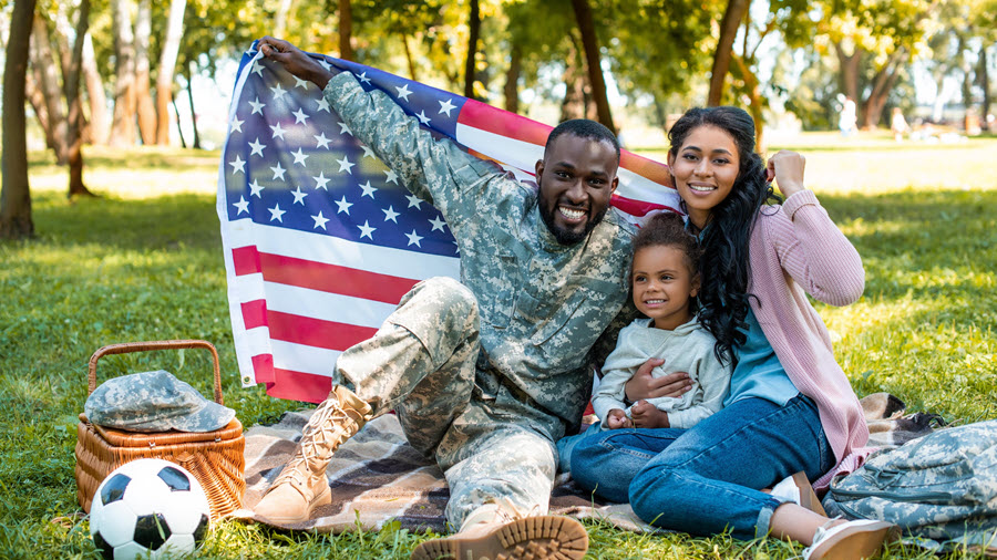 veteran and family enjoy picnic while holding US flag